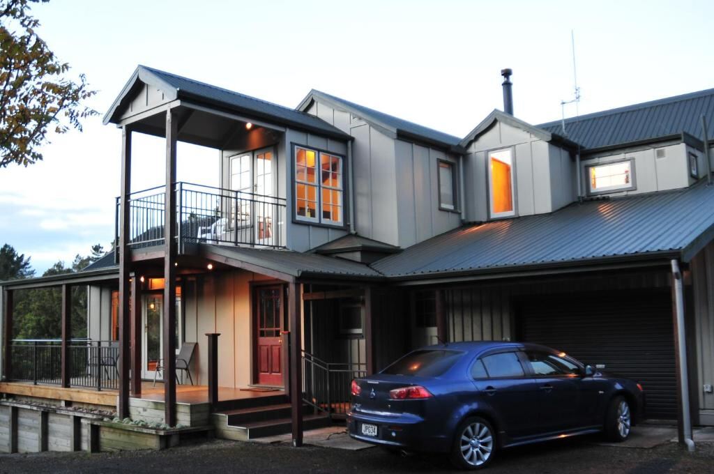 The house at dusk with lit windows and the guest verandah